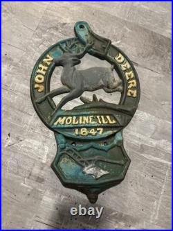 This is a vintage cast iron John Deere letter or match holder from Moline