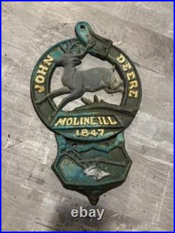 This is a vintage cast iron John Deere letter or match holder from Moline