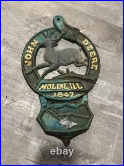 This is a vintage cast iron John Deere letter or match holder from Moline