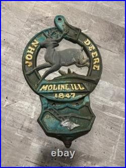 This is a vintage cast iron John Deere letter or match holder from Moline