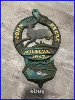 This is a vintage cast iron John Deere letter or match holder from Moline