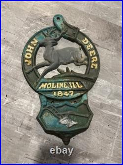 This is a vintage cast iron John Deere letter or match holder from Moline