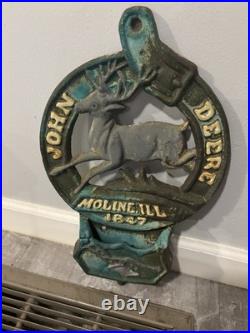 This is a vintage cast iron John Deere letter or match holder from Moline