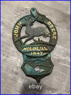 This is a vintage cast iron John Deere letter or match holder from Moline